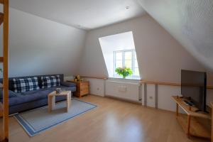 a living room with a blue couch and a window at Ferienwohnungen Appelhus in Pellworm