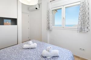 a bedroom with two towels on a bed with a window at Luxury Sea view Apartment in Nerja +17 photos