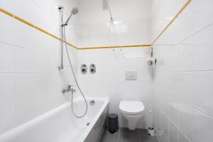 a white bathroom with a toilet and a bath tub at Hansa Nest in Hamburg