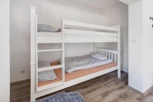 two white bunk beds in a room with wood floors at Hansa Nest in Hamburg