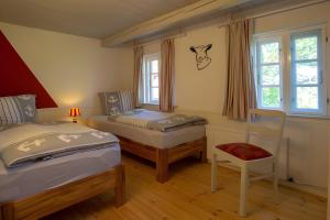 a bedroom with two beds and a chair in it at Ferienwohnungen Appelhus in Pellworm
