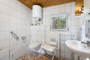 a white bathroom with a toilet and a sink at Bungalow 26 - Kimbucht in Reichendorf +15 photos