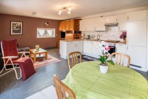 a kitchen and dining room with a green table and chairs at Haus Ruther - Wohnung 2 in Bad Saulgau +16 photos