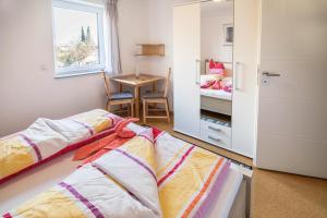 a bedroom with two beds and a table with a window at Haus Ruther - Wohnung 2 in Bad Saulgau