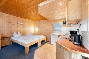 a small room with a bed in a kitchen at Bungalow 26 - Kimbucht in Reichendorf