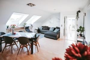 a living room with a table and chairs and a couch at Seeblick Wadee in Radolfzell am Bodensee