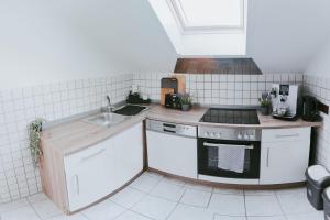 a small kitchen with a sink and a stove at Seeblick Wadee in Radolfzell am Bodensee +17 photos