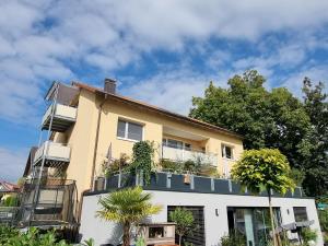 a yellow house with plants on the balcony at Seeblick Wadee in Radolfzell am Bodensee