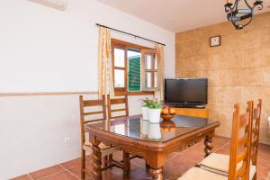 a dining room with a table and a television at Ses Llegitimes in Marratxí 