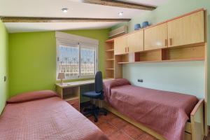 a bedroom with two beds and a desk and a window at Casa rural cavila in Pliego +18 photos