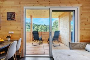 a living room with sliding glass doors leading to a deck at Mettmapark - Chalet 2 in Grafenhausen
