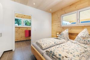 a bedroom with a bed and two windows at Mettmapark - Chalet 2 in Grafenhausen
