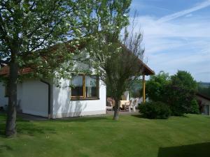 a white house with a table and chairs in a yard at Ferienhaus Uslar Gmbh Uslar in Uslar