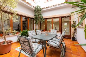 a patio with a table and chairs and plants at Cas Bunyoler in Cala Ratjada