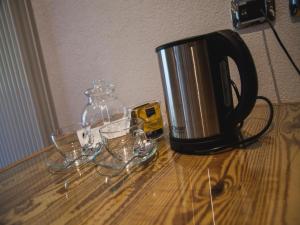 a coffee pot and glasses on a wooden table at Fedaia Joy Bnb in Canazei