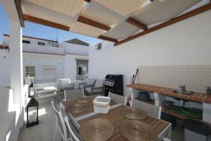 a balcony with a table and chairs and a grill at Bougainvillea House in Tavira +13 photos