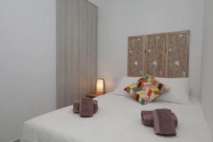 a bedroom with a white bed with two towels on it at Bougainvillea House in Tavira