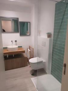 a bathroom with a toilet and a sink and a shower at Bougainvillea House in Tavira