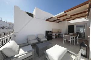 a balcony with chairs and a table on a building at Bougainvillea House in Tavira