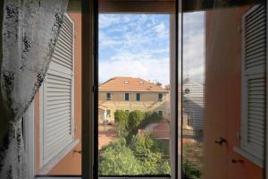 an open window with a view of a house at A due passi dal mare in Pietra Ligure