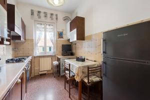 a kitchen with a table and a black refrigerator at A due passi dal mare in Pietra Ligure