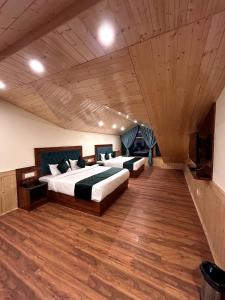 a large bedroom with two beds and a wooden ceiling at Hidden Heaven Waterfall view in Manāli +35 photos