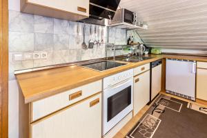 a kitchen with a sink and a stove at Haus am Mühlenbach in Hilzingen +15 photos