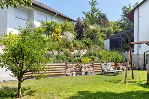 a garden with a stone wall and a bench at Haus am Mühlenbach in Hilzingen