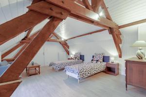 a attic room with two beds and a couch at Gite du cerisier in Lanouaille