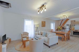 a living room with a white couch and a table at Gite du cerisier in Lanouaille