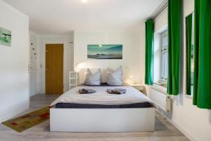 a bedroom with a large bed with green curtains at Bäckerhus - Ferienwohnung 5 in Wiek auf Rügen