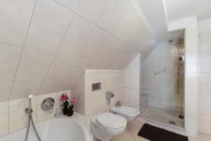 a white bathroom with a toilet and a shower at Ferienwohnung am Hügel in Schmallenberg