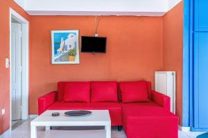 a living room with a red couch and a table at Veroni's studio 1 in Vathi