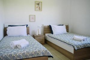 two beds in a bedroom with towels on them at Sunset Sea View Cottage in Nea Potidaea