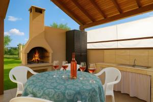 a table with wine glasses and a fireplace at Sunset Sea View Cottage in Nea Potidaea