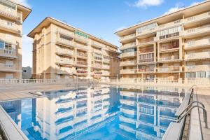 a swimming pool in front of a building at Viñamar 7 in La Mata +12 photos
