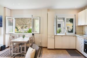 a kitchen with a table and chairs and windows at Stunning Views Kantouni Beach in Kalymnos +14 photos