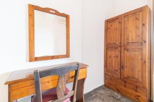 a wooden desk with a mirror and a wooden cabinet at Arianna Studio Ground Floor 8 in Paleokastritsa
