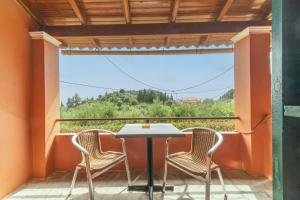 a table and chairs on a balcony with a view at Arianna Studio Ground Floor 8 in Paleokastritsa