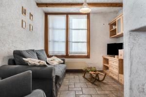 a living room with a couch and a television at Baita Al Rossat in Sant’Orsola