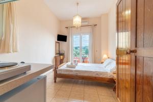 a small bedroom with a bed and a window at Arianna Studio 12 in Paleokastritsa