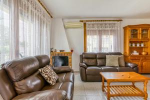 a living room with a leather couch and a table at Ampuriabrava in Empuriabrava
