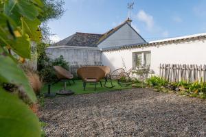 a patio with two chairs and a table in a yard at Ty Eole Maison Tout Confort 10p in Quiberon