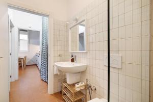 a white bathroom with a sink and a mirror at U Canetta 2 in Pietra Ligure