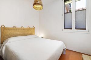 a white bedroom with a bed and a window at U Canetta 2 in Pietra Ligure