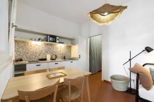 a kitchen and dining room with a wooden table at U Canetta 2 in Pietra Ligure
