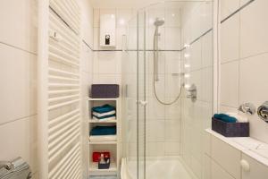 a white bathroom with a shower and a tub at Ferienwohnung Rübezahl in Brilon +14 photos
