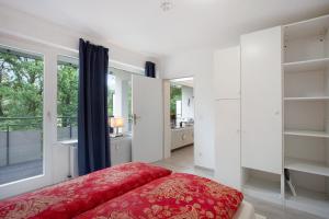 a bedroom with a red bed and a window at Ferienwohnung Rübezahl in Brilon