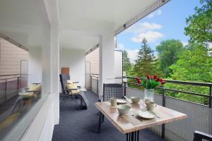 a balcony with a wooden table and a vase of flowers at Ferienwohnung Rübezahl in Brilon