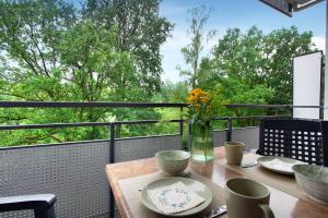 a table on a balcony with a view of trees at Ferienwohnung Rübezahl in Brilon